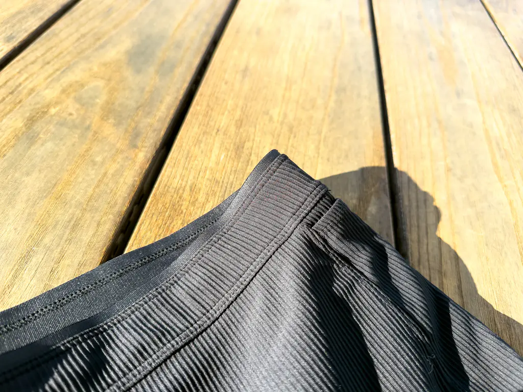 A closeup of the exterior of the waistband, showing the slightly stiffer fabric with a sharper edge, layered behind the face fabric. A closeup of the exterior of the waistband, showing the slightly stiffer fabric with a sharper edge, layered behind the face fabric.