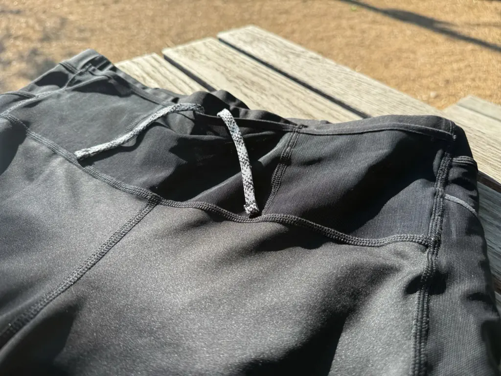A close up, angled view of the front of the half tights, showing the mesh front pockets and drawstring A close up, angled view of the front of the half tights, showing the mesh front pockets and drawstring