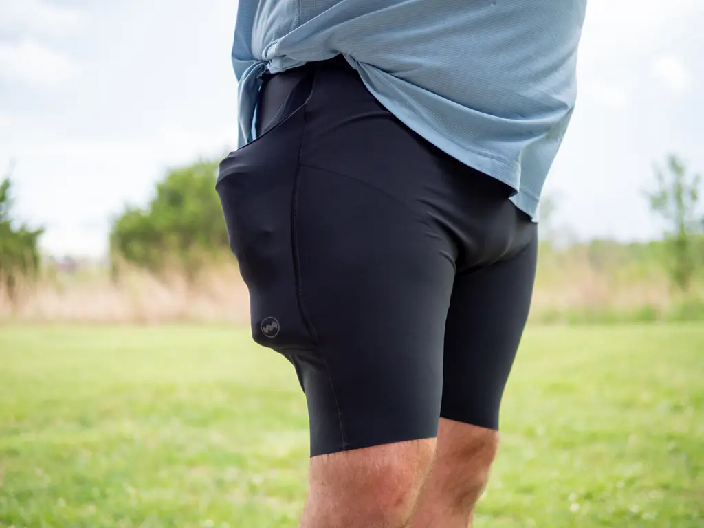 A front-side-view of a runner wearing the half tights, with the side pockets loaded with both a 500ml soft flask and a 150ml nutrition flask, which bulges quite a bit. A front-side-view of a runner wearing the half tights, with the side pockets loaded with both a 500ml soft flask and a 150ml nutrition flask, which bulges quite a bit.