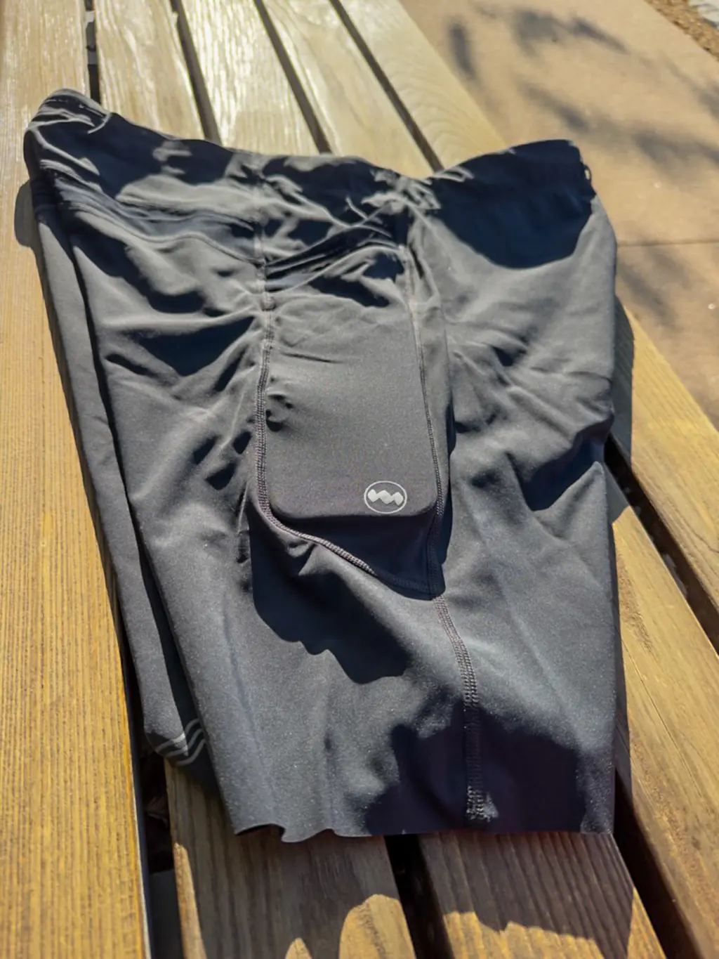 An overall side view of the half tights, showing the stacked pockets, with an iPhone Pro Max case in the rear side pocket An overall side view of the half tights, showing the stacked pockets, with an iPhone Pro Max case in the rear side pocket