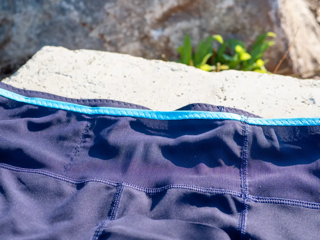 A closeup of the stretch-mesh waistband storage, showing the zig-zag stitch separating the smaller left section